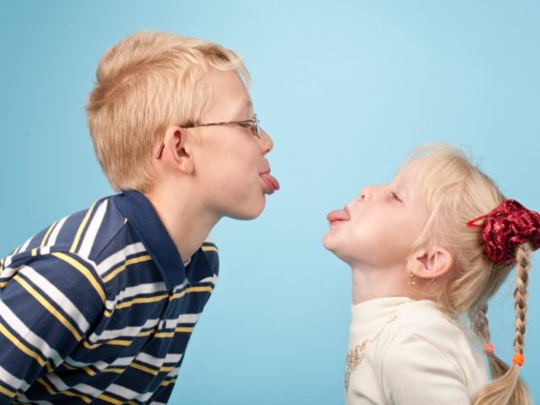 little girl and boy making fun of each other